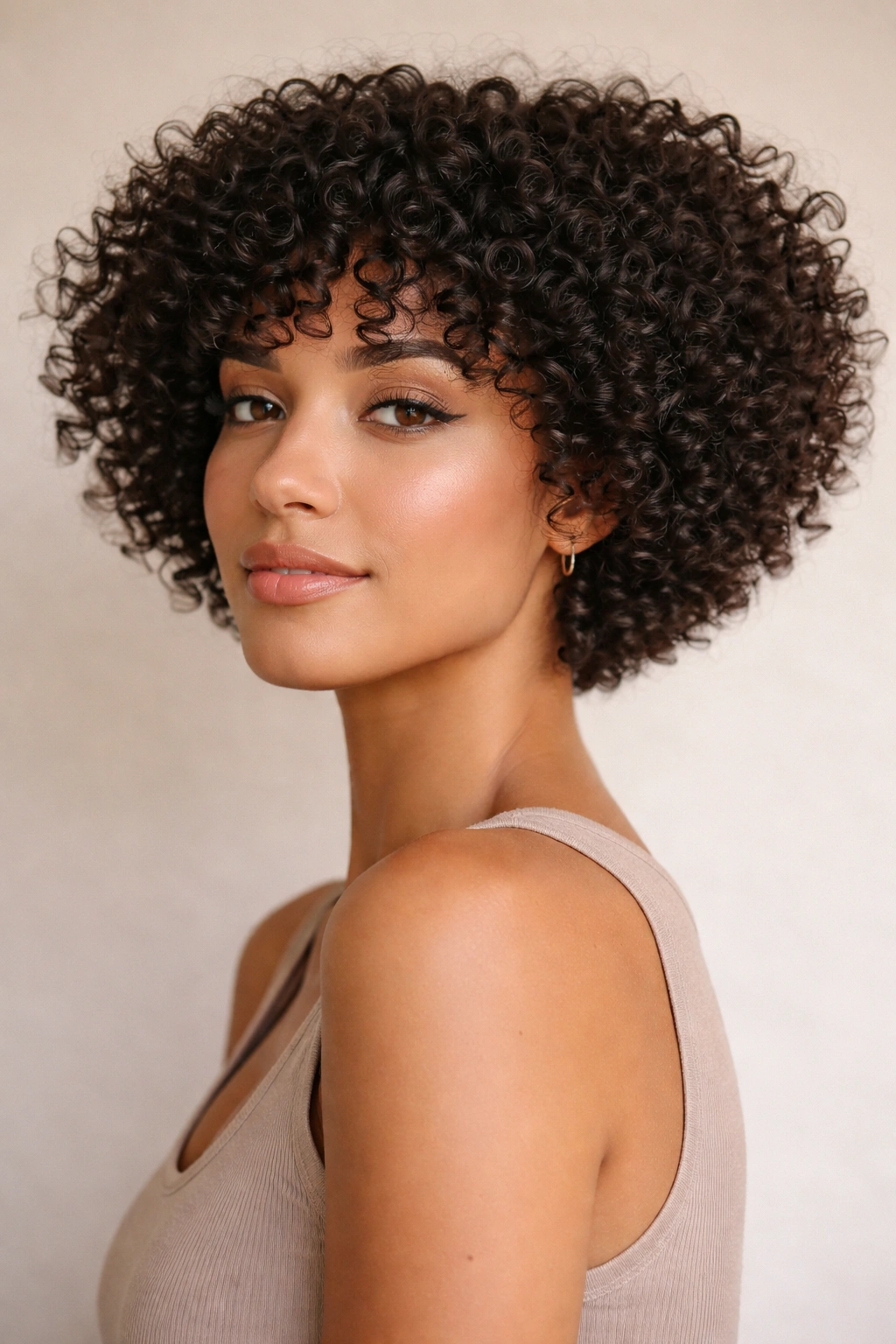 Blunt tapered curly cut with clustered curls for fullness.