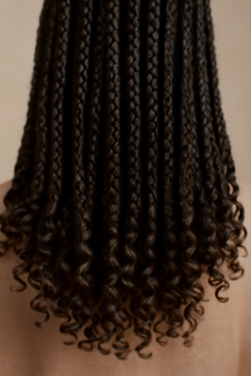 Close-up of box braids with curly ends, showing curled tips and texture