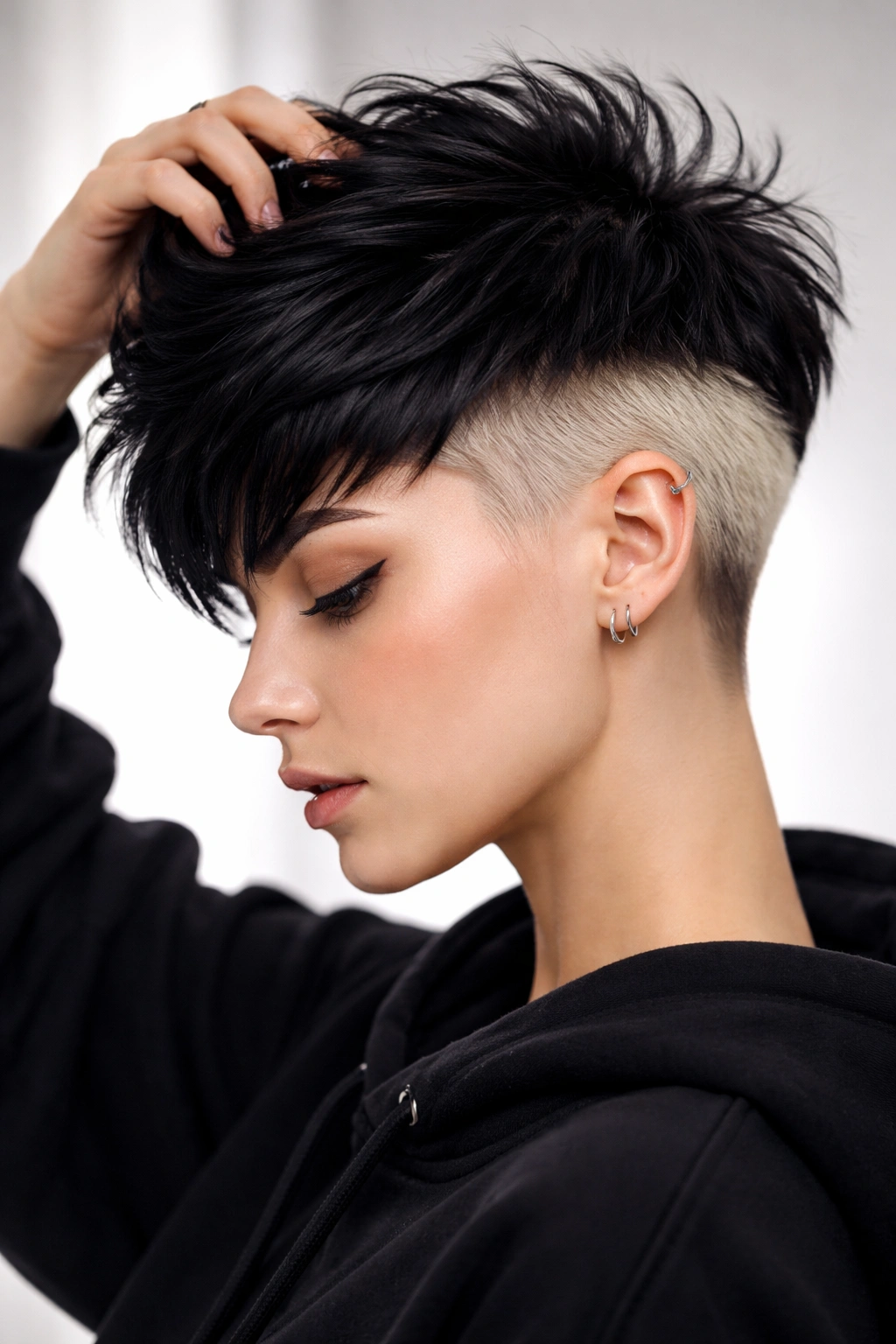 Pixie hairstyle with dark top and bright undercut color visible