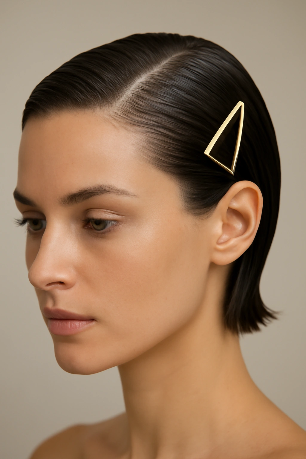 Sleek gel-slicked hairstyle with geometric clip.