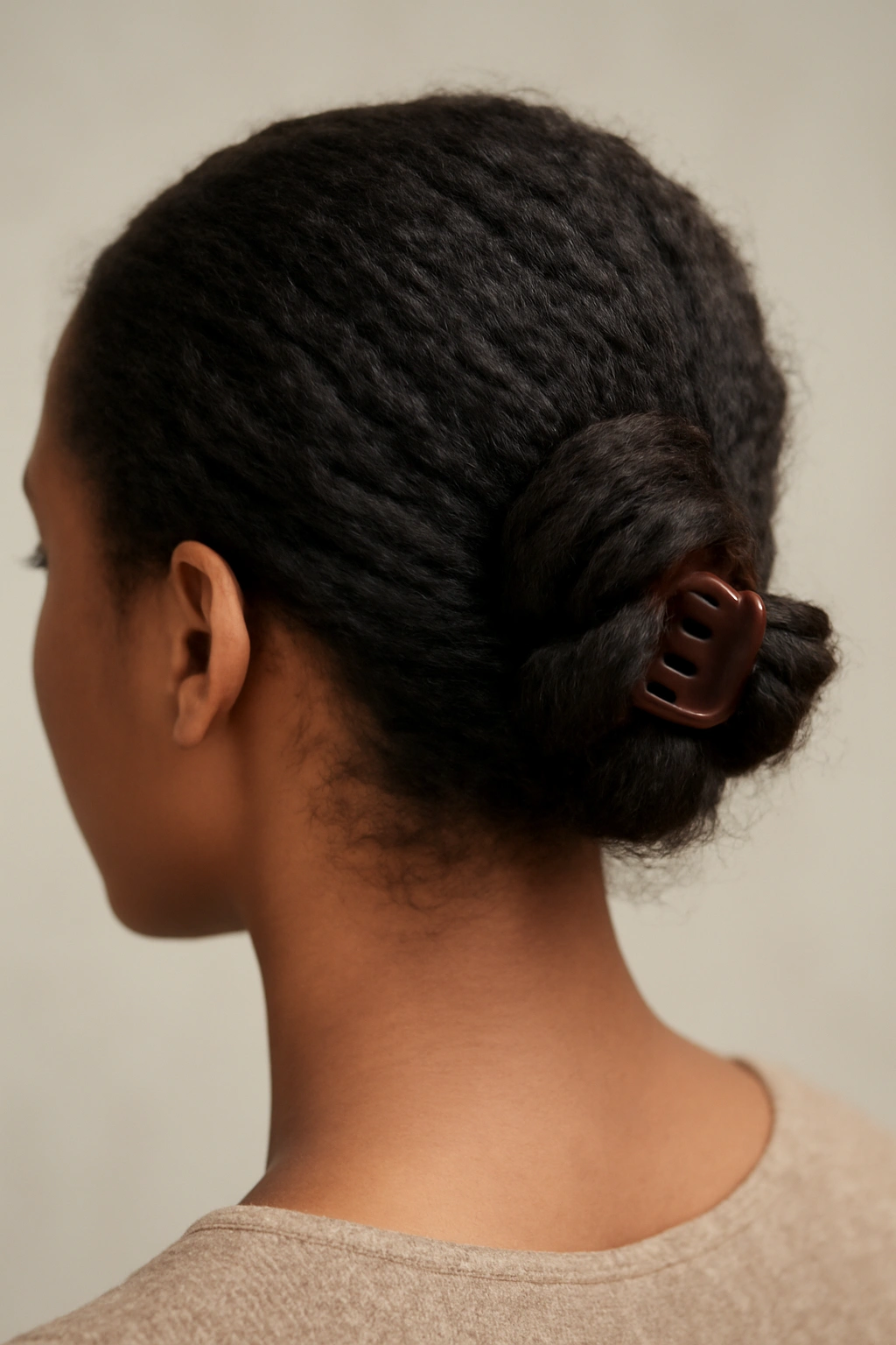 Back view of a side-swept twisted knot secured with a claw clip